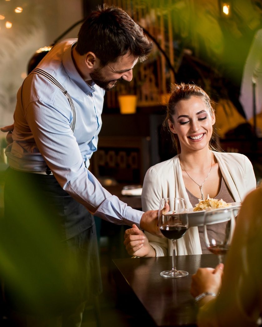 Garson, restoran masasındaki çifte servis yapıyor
